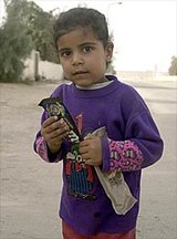 Beeldvergroting: SWEET TREAT ? An Iraqi girl in Umm Qasr holds a bag of M&M\'s she received from a U.S. Army civil affairs officer.